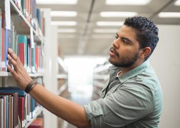student looking for books in the library